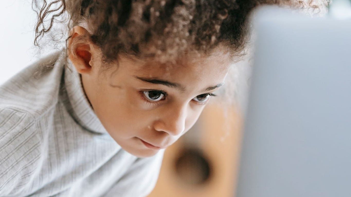 Niña frente a la pantalla de una computadora.