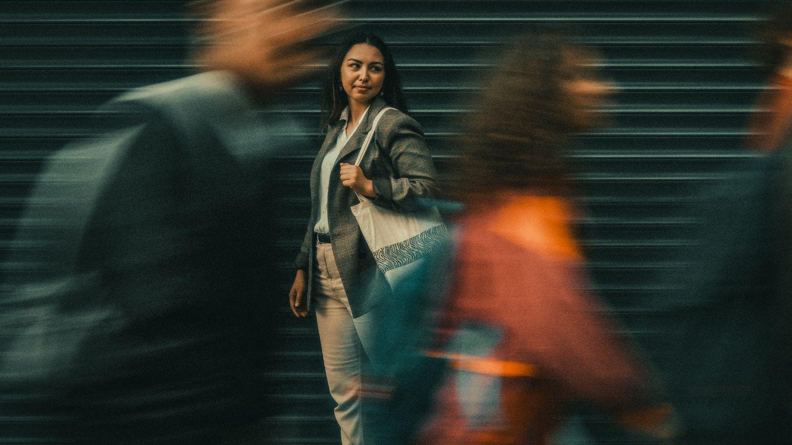 Mujer entre personas que caminan en un espacio público.