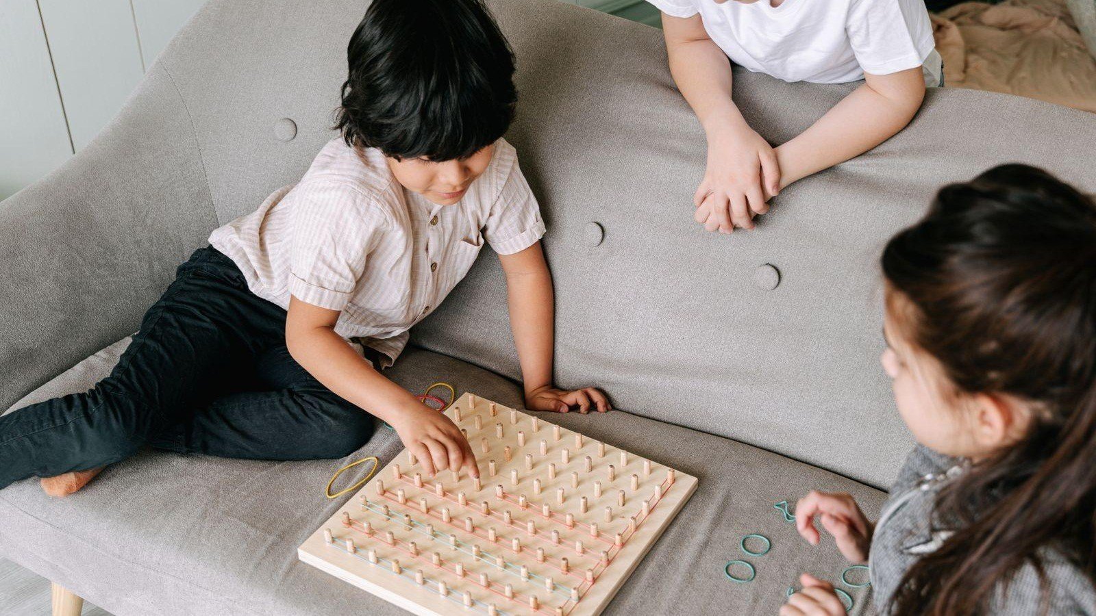 Niño y personas adultas jugando un juego de mesa.