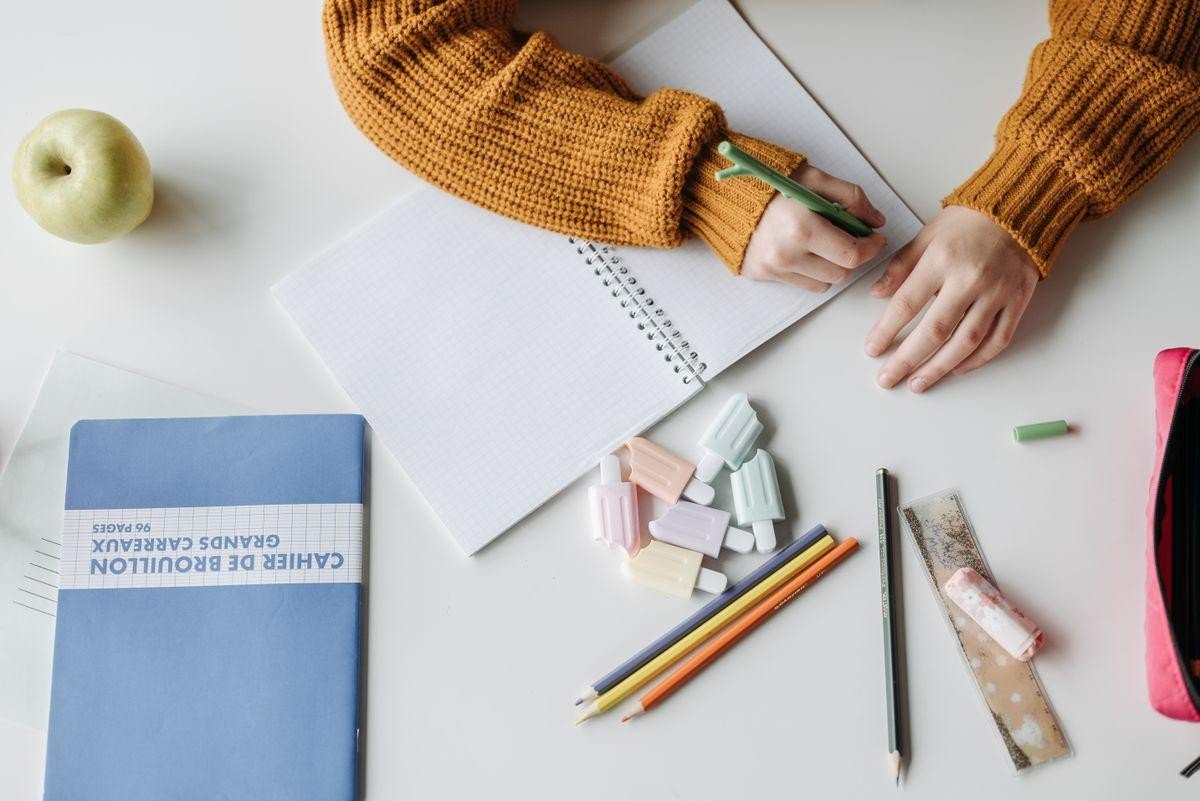 Niñas y niños dibujando y escribiendo con lápices de colores.