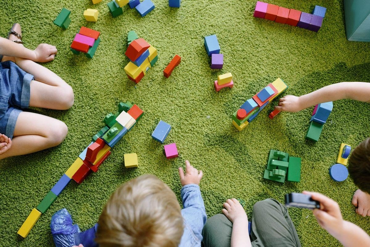 Niñas y niños jugando con bloques de construcción.
